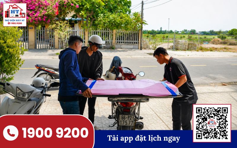 Kỹ thuật viên vận chuyển tivi đến nhà khách hàng để kiểm tra và sửa chữa thiết bị điện tử.