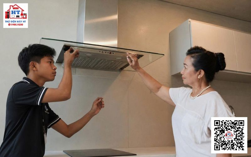 Kiểm tra rung động máy hút mùi Kỹ thuật viên kiểm tra máy hút mùi đang hoạt động, tập trung vào khu vực động cơ và cánh quạt để phát hiện rung động